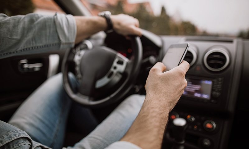 A driver uses a mobile phone at the wheel.