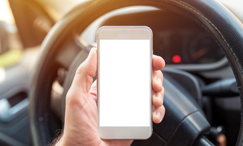 Driver holding smartphone.