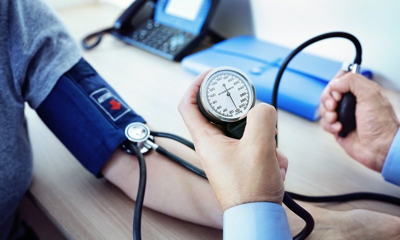 A doctor checks a patient’s blood pressure