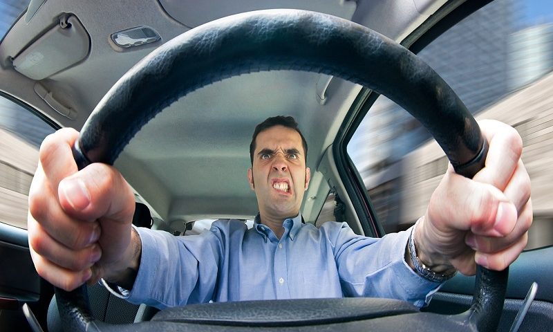 An angry man driving behind the wheel