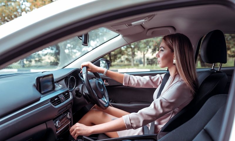 A young driver behind the wheel of her car