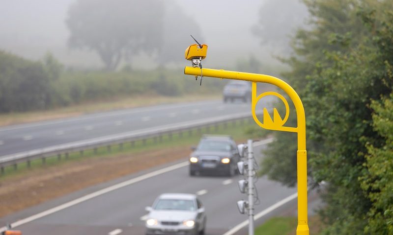 Drivers pass beneath a yellow average speed camera