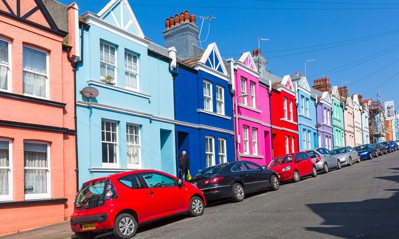 Colourful terraced houses with cars parked outside