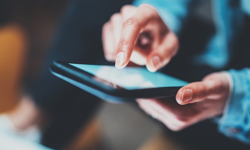 Closeup view of woman holding modern smartphone in hands