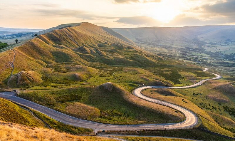 Winding road and hills at sunset in the Peak District