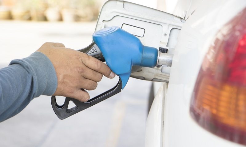 Person filling car with fuel at a station