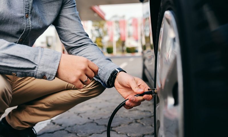 Man inflating his car tyre.