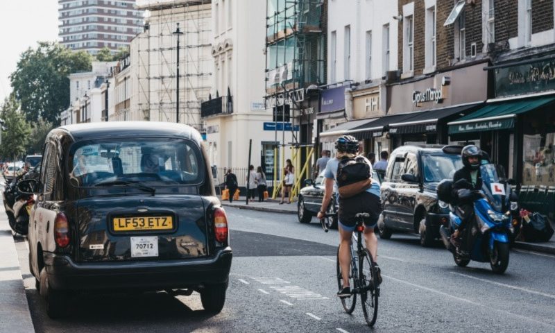 Cyclist passing cars on the road