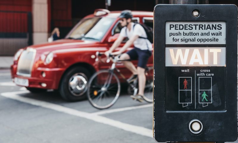 Car and cyclist waiting at a pedestrian crossing