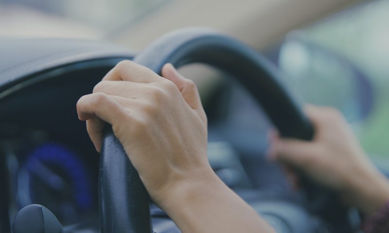 Woman’s hands on steering wheel